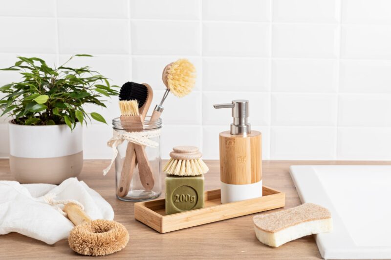 Bathroom cleaning products on wooden counter next to a sink
