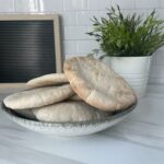 Stack of fluffy, freshly baked sourdough pita bread, perfect for wraps and dips