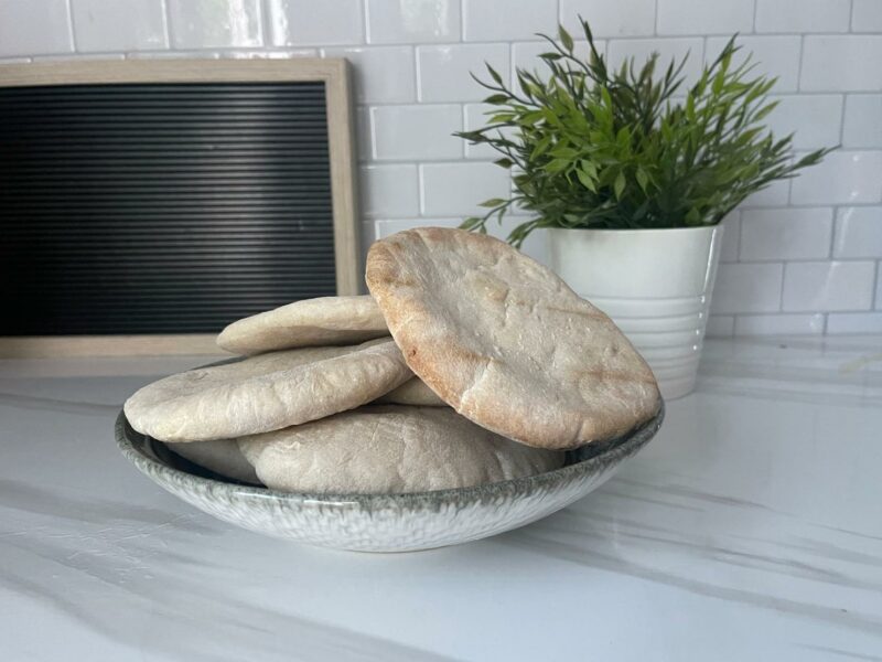 Stack of fluffy, freshly baked sourdough pita bread, perfect for wraps and dips