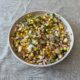 Grilled corn and peach salsa served in a bowl with fresh herbs and lime